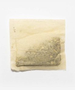 Foto em fundo cinza claro de um sachê de chá yuyo de lavanda e sabugueiro.