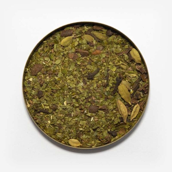 Chá mate matequero em recipiente metálico ao centro. Fundo cinza claro. Erva-mate verde fresca pura folha com nibis de cacau, cardamomo, erva-doce, cravo e canela.