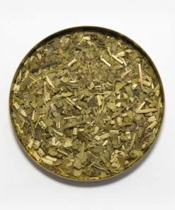 Foto de uma tampa arredonda com erva-mate descansada em seu interior. Erva-mate com presença de palito e folhas bem grossas. Nenhum pó. Pouca presença de palitos.