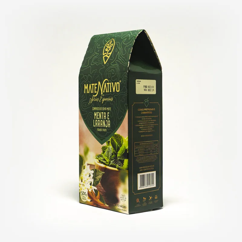 Composto de erva-mate com menta e laranja. Pacote de 500 gramas em fundo branco virado pra esquerda. Pacote verde escuro com detalhes em amarelo. Fotografia de folhas de menta e erva-mate. Em escrito: Composto de erva-mate menta e laranja. Folhas e fruto.