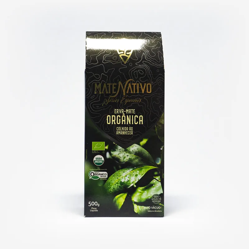 Erva-mate orgânica colhida no amanhecer. Pacote de 500 gramas em fundo branco. Pacote preto com detalhes cinzas. Fotografia de folhas de erva-mate com orvalho no pacote. Em escrito: Matet Nativo, series especiais. Erva-mate Orgânica colhida ao amanhecer.