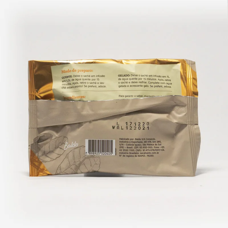 Pacote de chá mate magna em fundo cinza claro de costas. Pacote com tons de marrom com laranja. Modo de preparo disponível na descrição do produto.