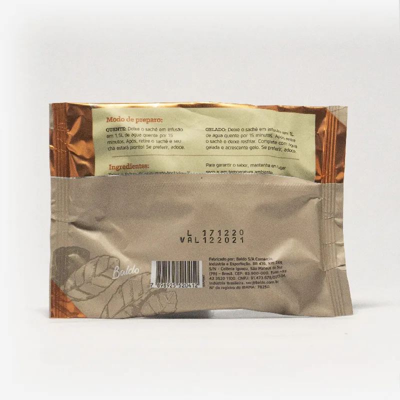 Pacote de chá mate magna em fundo cinza claro de costas. Pacote com tons de marrom com laranja escuro. Modo de preparo disponível na descrição do produto.