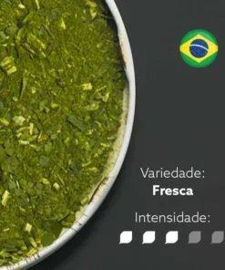 Erva-mate Chimarrão Orgânica Mate Nativo em recipiente metálico ocupando metade esquerda da imagem. Fundo cinza escuro e bandeira do Brasil circular no canto superior direito. Em escrito: Varidade Fresca com intensidade nível 3 de 5.