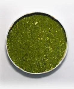 Erva-mate Chimarrão Orgânica Mate Nativo em recipiente metálico no centro. Fundo cinza claro. Erva-mate verde fresca com pouca ou nenhuma presença de palitos. erva-mate verde fina.